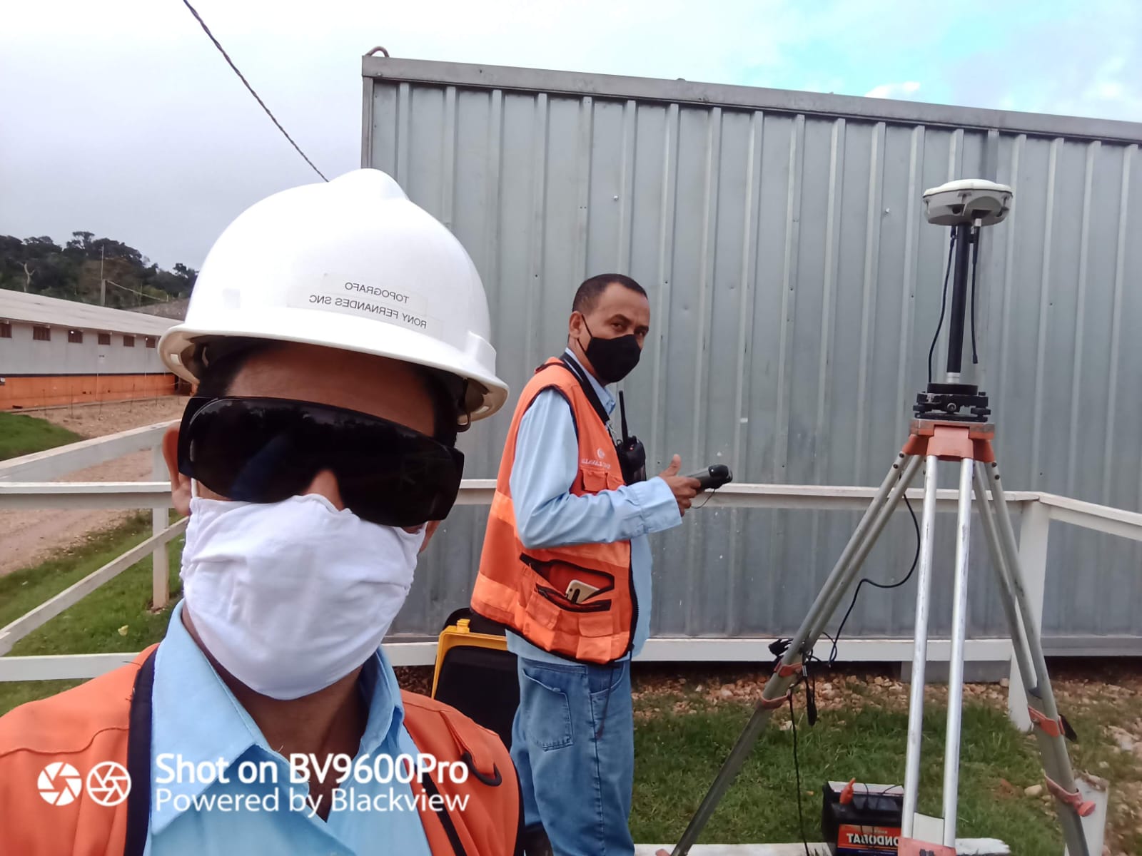 Dupla de campo operando equipamento de geodésia em obra