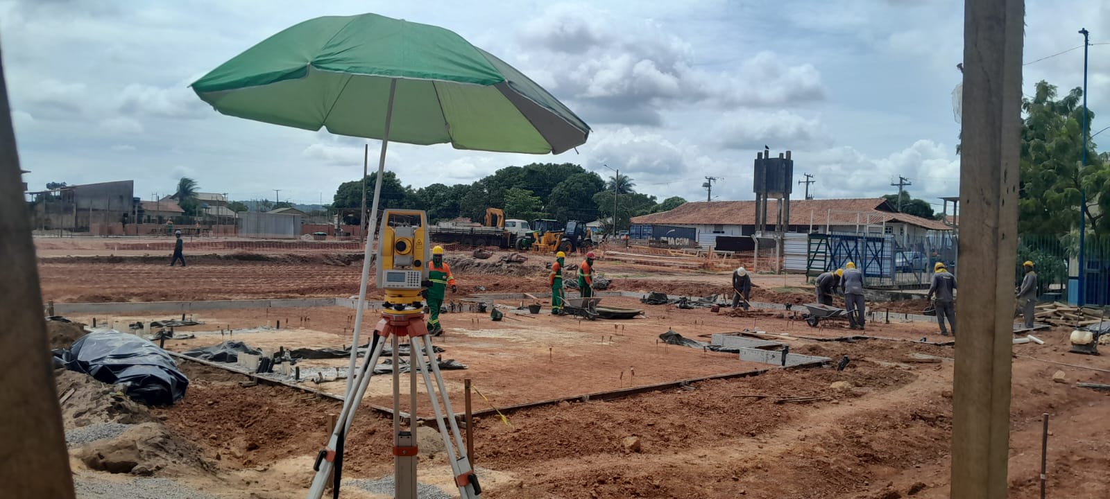 Canteiro de terraplenagem com estação total e equipe em campo